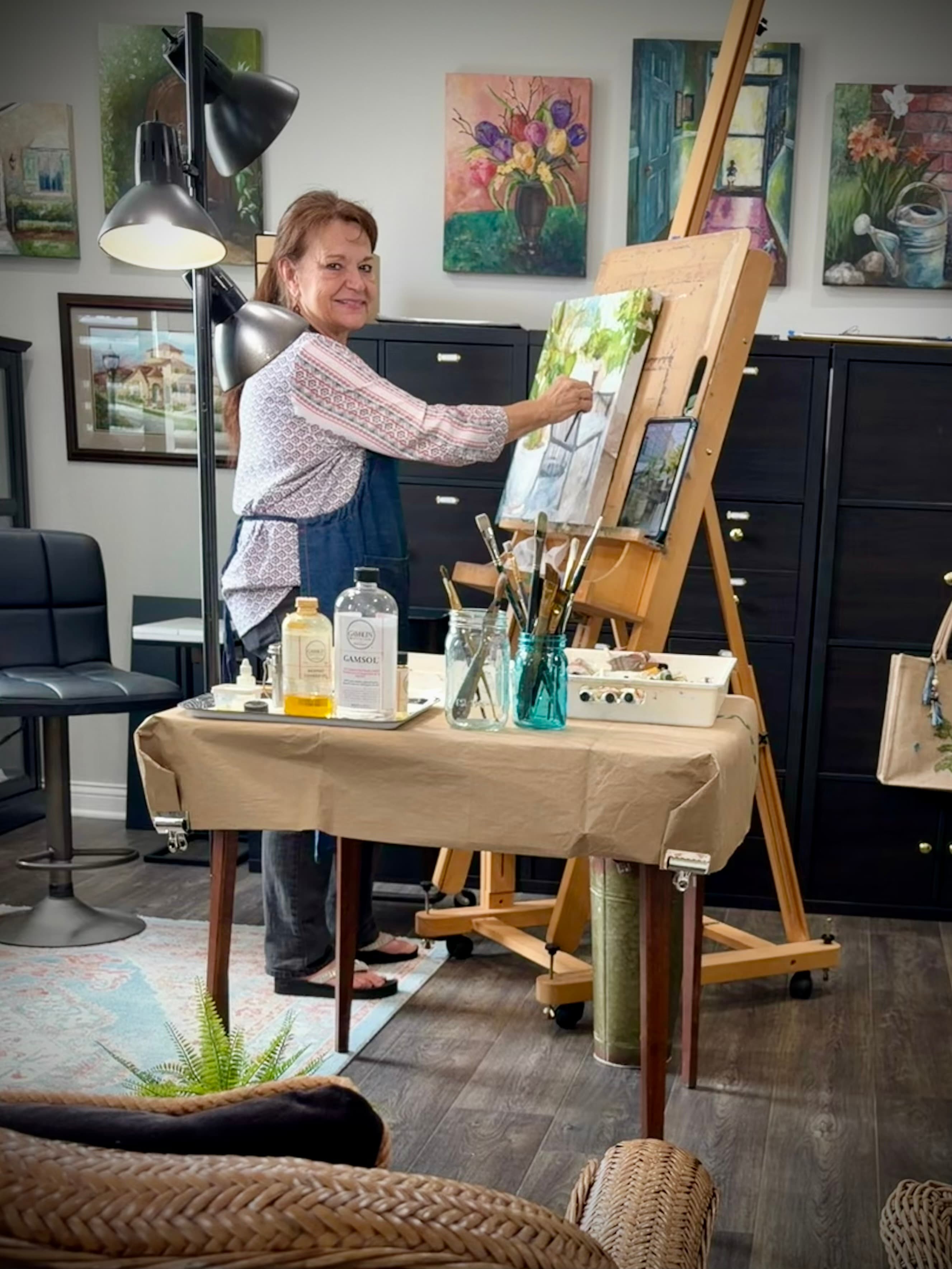 Judy's studio — easel, fiddle leaf fig, paintings on the wall